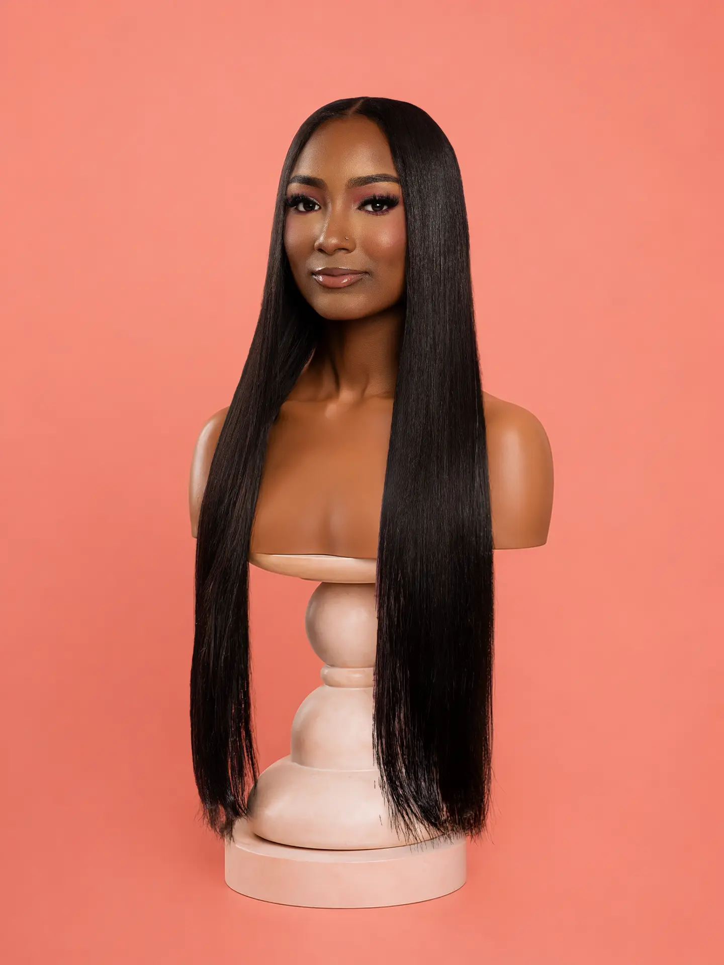 Silk Pressed — Straight luxury wig on mannequin against a salmon pink backdrop